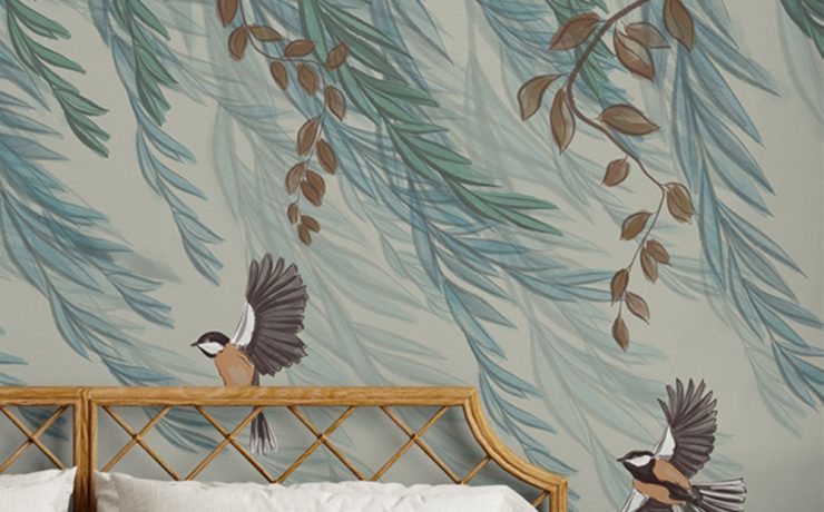 Illustrative wallpaper with birds and leafy branches, inspired by William Morris designs, above a cozy bed.