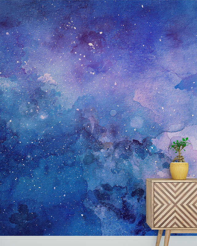 A vibrant galaxy-themed wall showcasing blue wallpaper trends, with a geometric wooden cabinet and a small plant