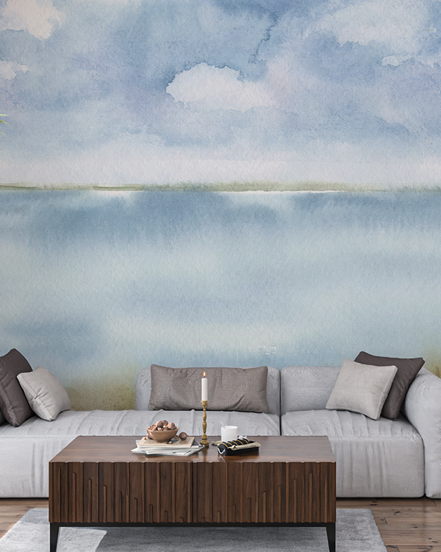 Modern living room featuring a serene blue wallpaper trend with a watercolor landscape design, a gray sofa, and a wooden coffee table