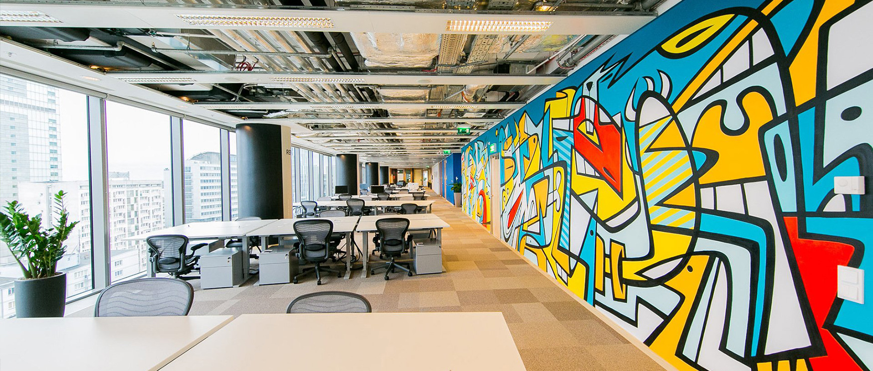 modern-office-space-with-an-open-layout-featuring-blue-wallpaper-for-commercial-spaces-adorned-with-vibrant-abstract-graffiti-wallpaper Modern office space with an open layout, featuring blue wallpaper for commercial spaces adorned with vibrant, abstract graffiti wallpaper