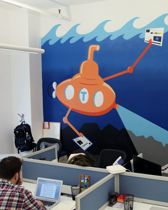 office-space-with-blue-wallpaper-for-commercial-spaces-featuring-a-cartoon-orange-submarine-and-a-worker-at-a-desk Office space with blue wallpaper for commercial spaces featuring a cartoon orange submarine and a worker at a desk