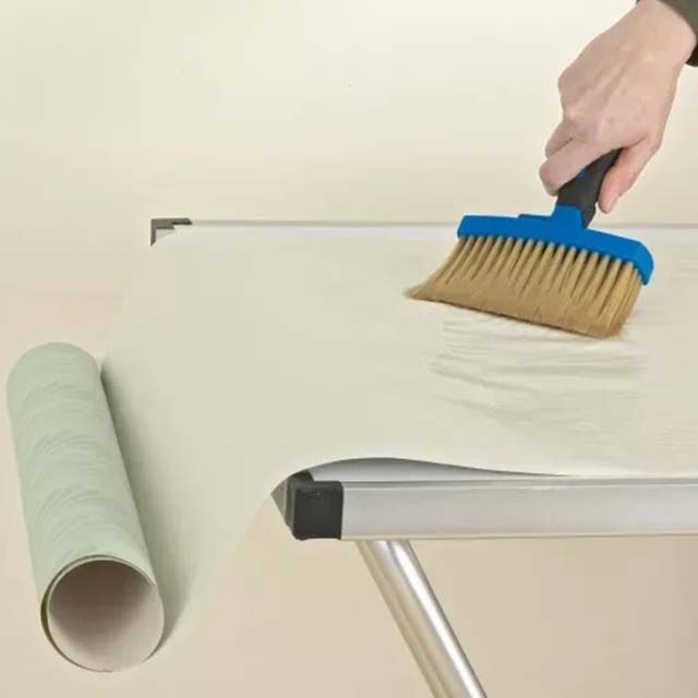 Applying-paste-on-wallpaper-during-the-Wallpaper-Installation-process-with-a-hand-using-a-brush-to-smooth-it-out Applying paste on wallpaper during the Wallpaper Installation process, with a hand using a brush to smooth it out.