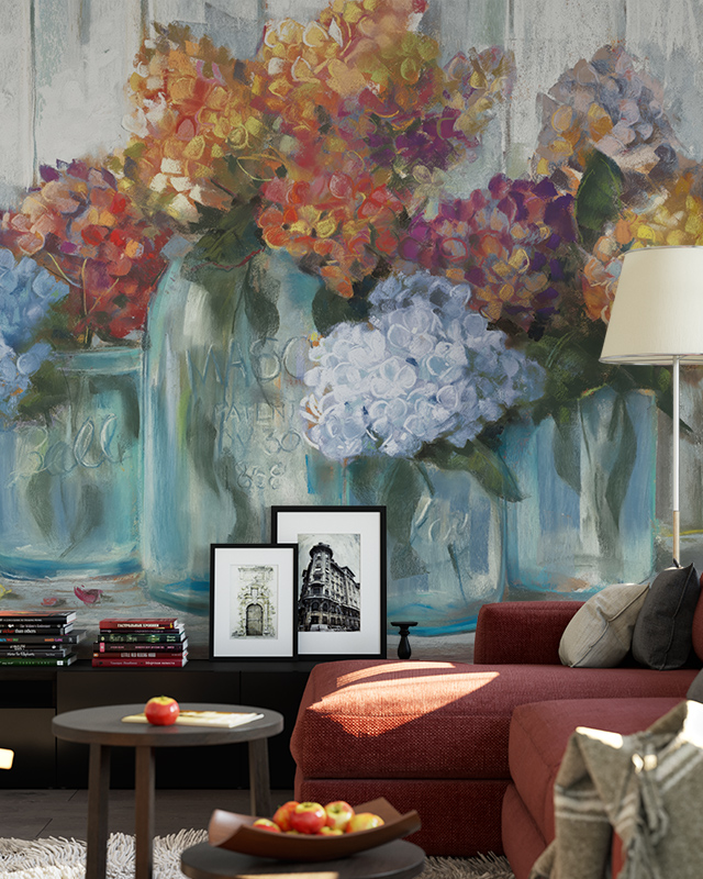 Floral Wallpaper vs Other Styles with vibrant flowers in jars. In front of the wallpaper, a modern sofa, framed pictures, and a floor lamp.