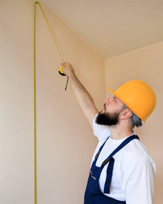 a-worker-in-a-hard-hat-measuring-a-wall-for-abstract-wallpaper-for-commercial-spaces A worker in a hard hat measuring a wall for Abstract Wallpaper for Commercial Spaces