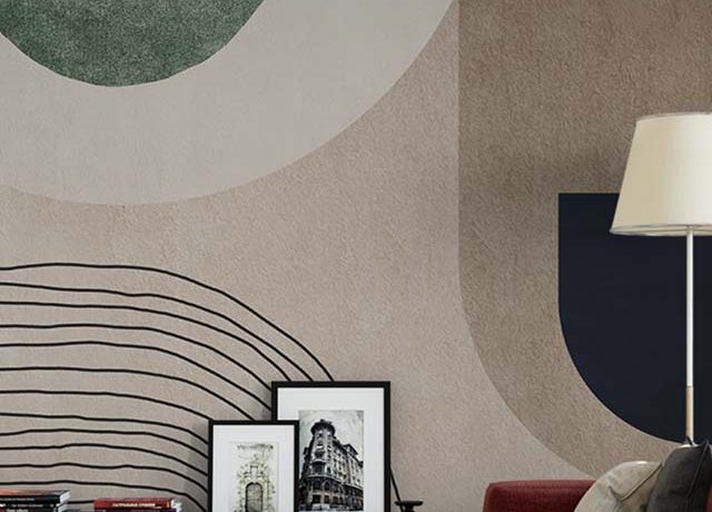 Abstract wallpaper with geometric shapes in green, beige, and black behind a modern sofa, ideal for Abstract Wallpaper for Commercial Spaces.