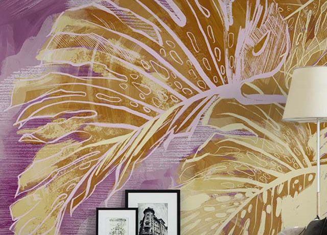 Abstract wallpaper with large, golden leaves on a purple background behind a modern sofa, perfect for Abstract Wallpaper for Small Spaces.