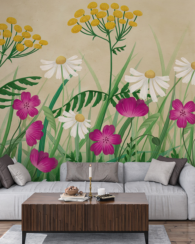 Bright floral wallpaper for different rooms showcases vibrant yellow, white, and purple flowers against a beige backdrop, enhancing a living room with a light gray sofa, a wooden coffee table with candles, and neutral cushions.