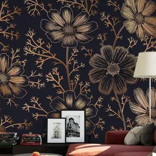Floral Wallpaper Trend with large gold and black flowers on a dark background behind a lamp, sofa, and framed pictures.