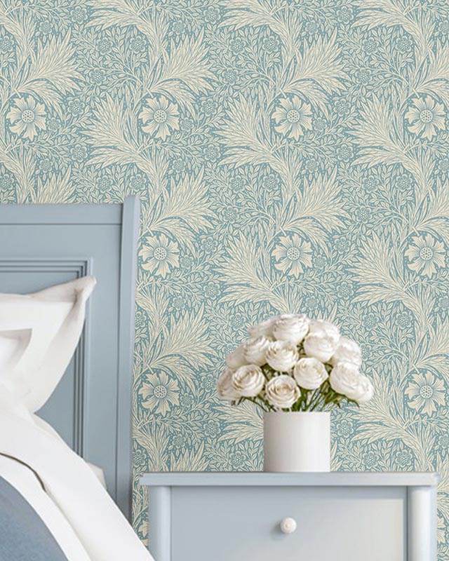 Light blue bedroom with intricate William Morris wallpaper patterns and a bedside table holding a vase of white roses Light blue bedroom with intricate William Morris wallpaper patterns and a bedside table holding a vase of white roses.