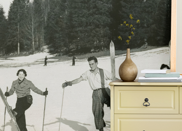 A black-and-white vintage skiing scene wallpaper paired with a modern dresser. Tips on how to choose vintage wallpaper styles.