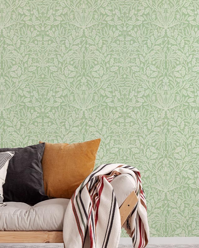 a-cozy-couch-with-pillows-and-blanket-in-front-of-green-william-morris-wallpaper-vs-modern-wallpaper-styles A cozy couch with pillows and blanket in front of green William Morris wallpaper vs. Modern Wallpaper Styles.