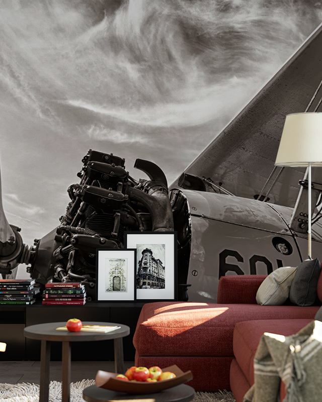a-living-room-with-vintage-airplane-themed-wallpaper-a-red-sofa-framed-photos-and-a-side-table-demonstrating-how-to-choose-vintage-wallpaper-for-accent-wall A living room with vintage airplane-themed wallpaper, a red sofa, framed photos, and a side table, demonstrating how to choose vintage wallpaper for accent wall.