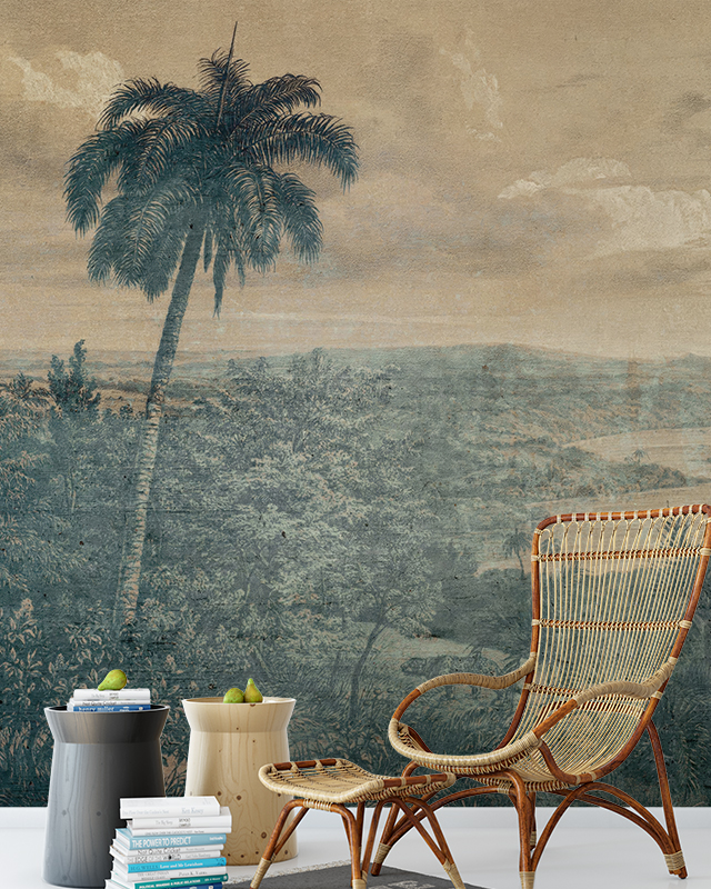 a-vintage-palm-tree-wallpaper-with-a-wicker-chair-side-tables-and-stacked-books-in-front-how-to-choose-vintage-wallpaper A vintage palm tree wallpaper with a wicker chair, side tables, and stacked books in front. How to choose vintage wallpaper.