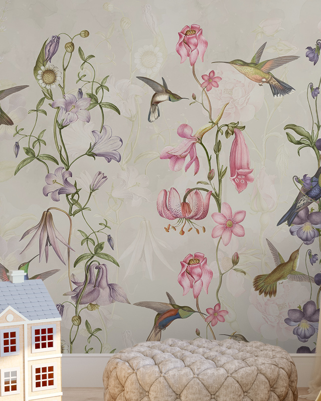 Beige Wallpaper for nursery featuring colorful hummingbirds and pink, purple, and white flowers with a toy house and pouf.