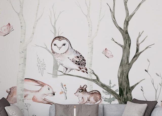 Illustration of an owl, rabbit, and mouse in a forest scene, with a gray sofa and coffee table in front, featuring removal of peel and stick wallpaper.