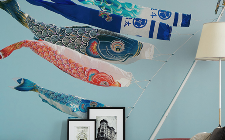 Japandi Monochrome Wallpaper Designs with colorful fish kites, modern furniture, and framed artwork on a side table.