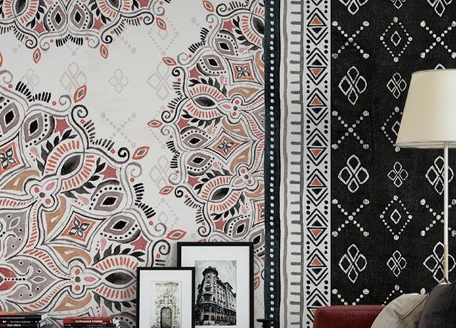 Living room with intricate patterned peel and stick wallpaper alongside framed pictures, red sofa, and floor lamp – highlighting peel and stick vs. traditional wallpaper contrast.