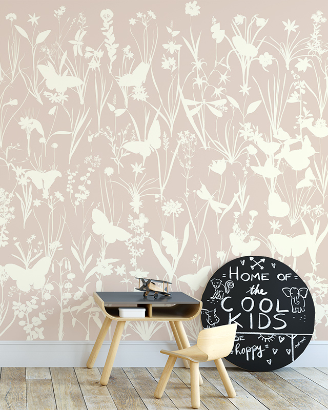 Nursery with a children's table, chair, and chalkboard in front of Beige Wallpaper for nursery featuring white floral and butterfly patterns.