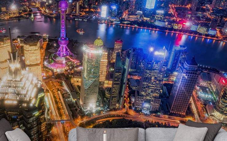 Office wallpaper ideas for productivity featuring a vibrant aerial cityscape at night behind a modern gray sofa.