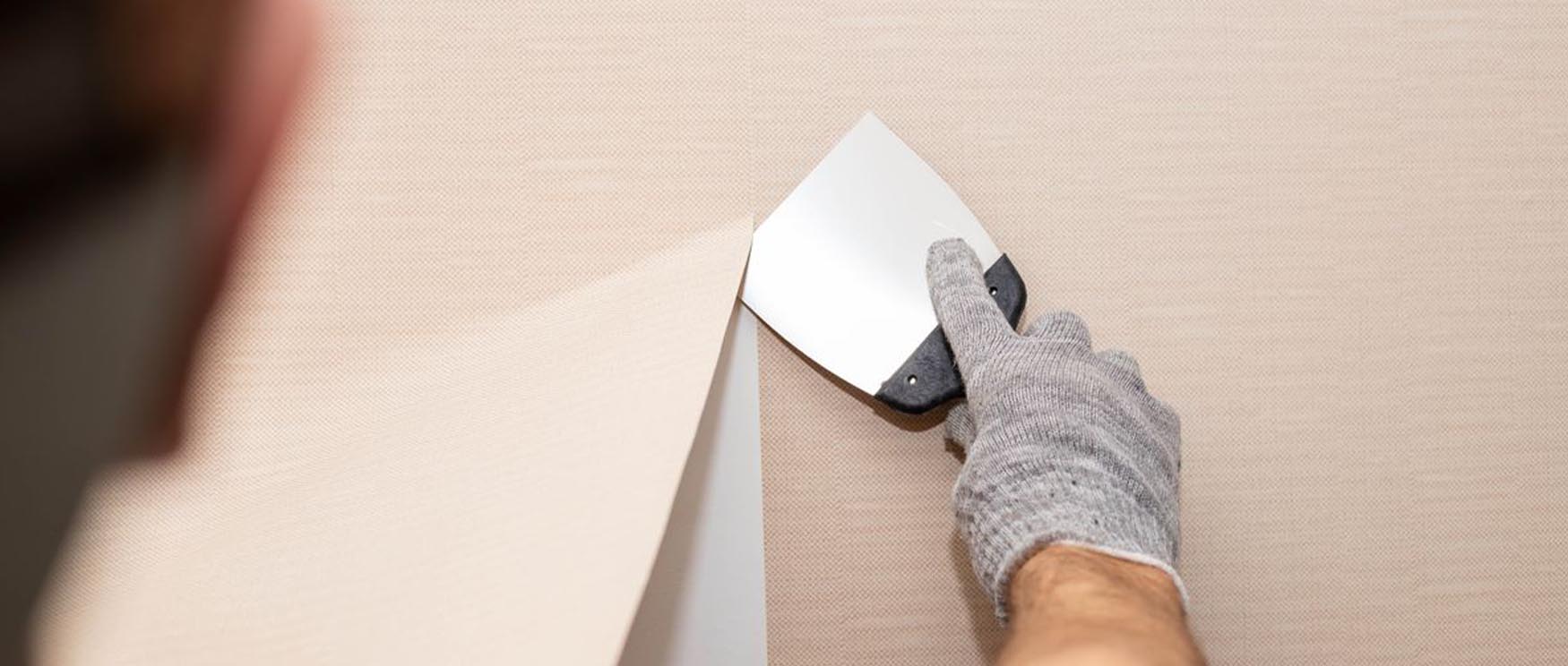 person-using-a-scraper-tool-to-assist-in-the-removal-of-peel-and-stick-wallpaper Person using a scraper tool to assist in the removal of peel and stick wallpaper.