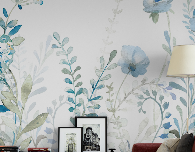 Removable wallpaper with blue floral design behind a red sofa and framed art pieces on a black console, showcasing remove removable wallpaper benefits.