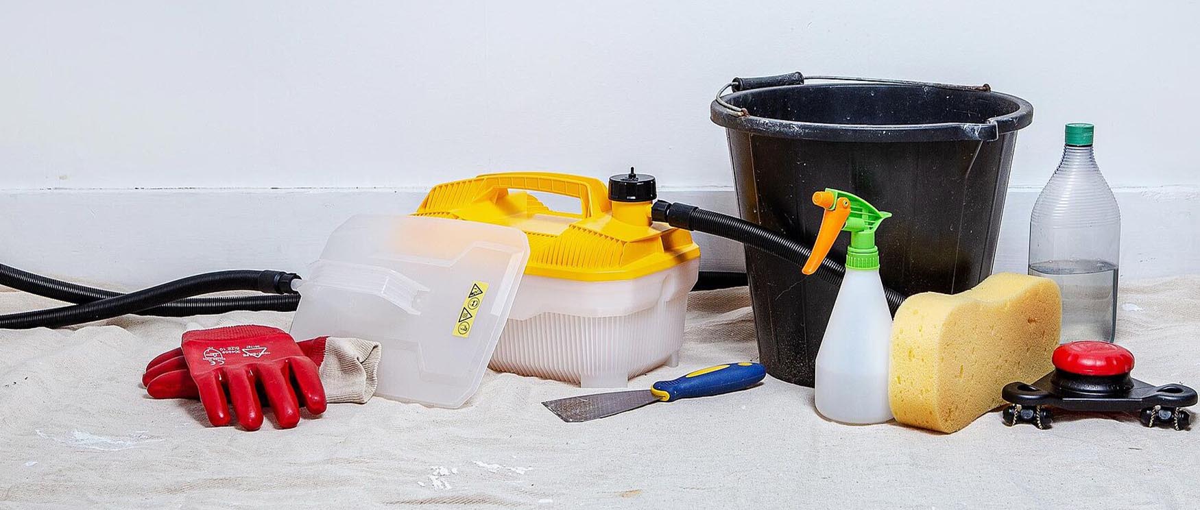 tools-and-supplies-for-the-removal-of-peel-and-stick-wallpaper-including-gloves-sponge-and-scraper Tools and supplies for the removal of peel and stick wallpaper, including gloves, sponge, and scraper.