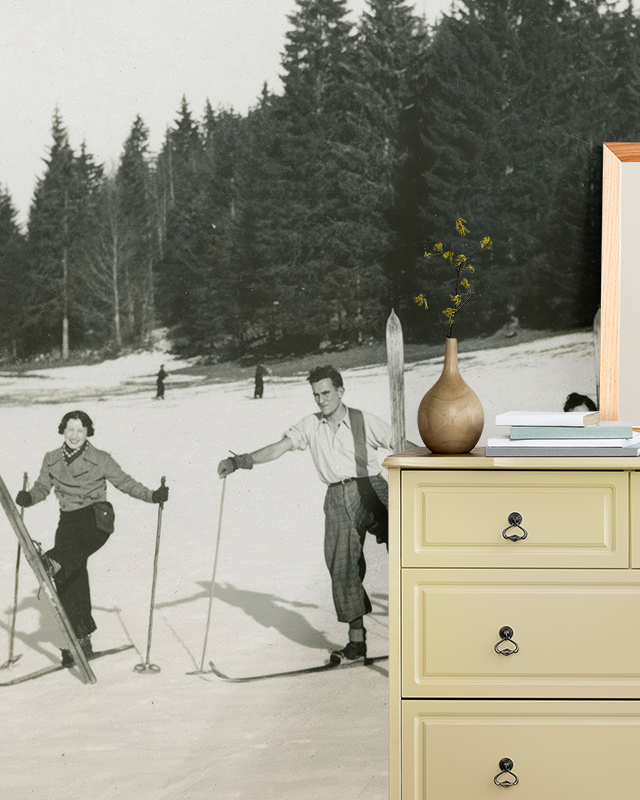 Vintage Wallpaper for Small Spaces featuring a black-and-white skiing scene, complemented by a yellow dresser with decor.