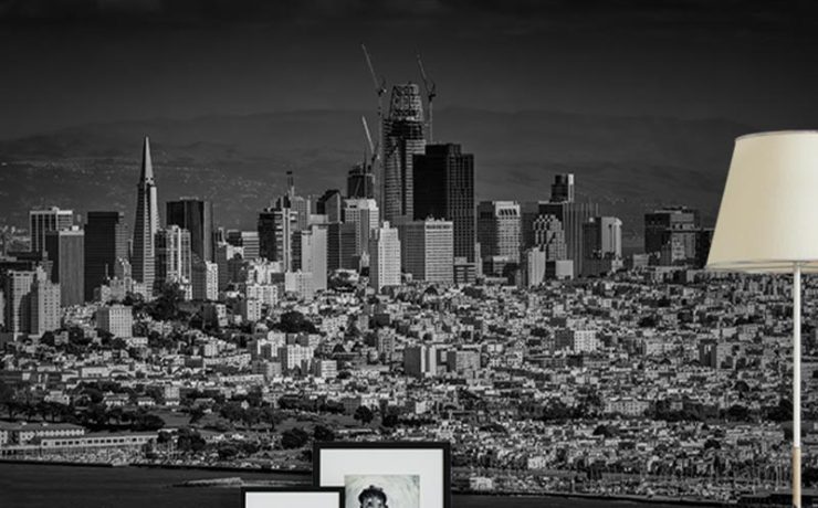 A black-and-white city skyline mural behind a modern living room setup, ideal Urban Wallpaper for Open-Concept Spaces.