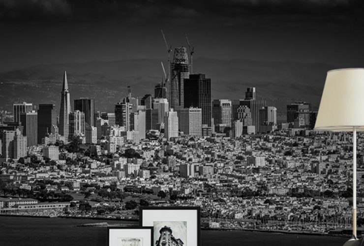 A black-and-white city skyline mural behind a modern living room setup, ideal Urban Wallpaper for Open-Concept Spaces.