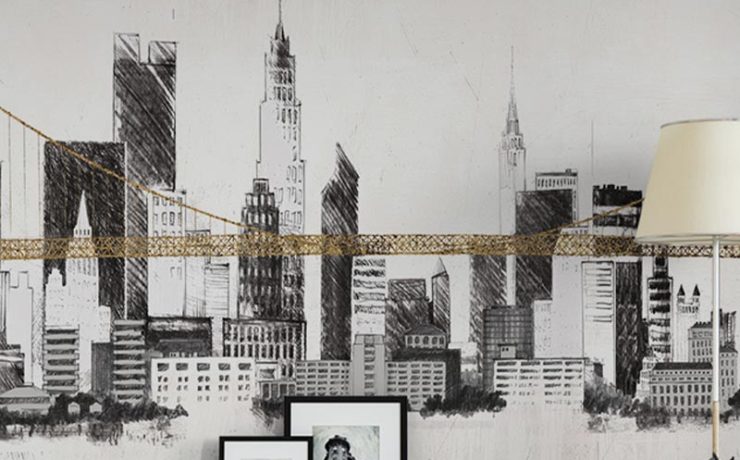 A black and white city skyline mural with a gold bridge detail in a modern living room, illustrating Urban Wallpaper Trends.