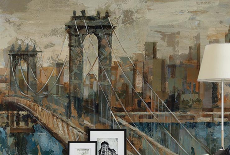 A textured mural of a bridge and city skyline behind a lamp, books, and framed art in a living room, showcasing Urban Wallpaper for Commercial Spaces.