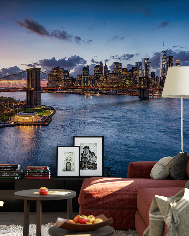 Living room with a cityscape mural featuring a lit-up skyline and bridge at dusk, showcasing types of urban wallpaper designs.