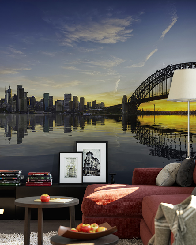Living room with a mural of a city skyline and bridge reflected on water at sunset, showcasing types of urban wallpaper designs.