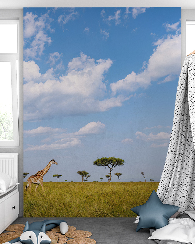 A giraffe wanders under a vast sky blue wallpaper, creating a vibrant scene for commercial spaces. 