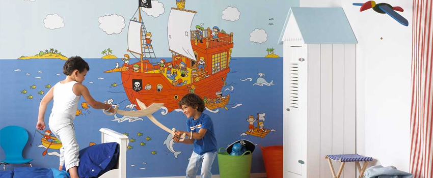 Kids' room with playful pirate ship mural on a blue wallpaper. 