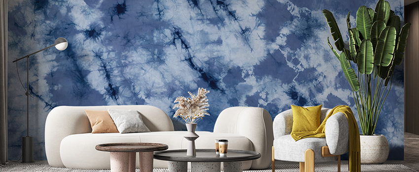 Modern living room featuring tie-dye pattern blue wallpaper with a white sofa and green plant. 