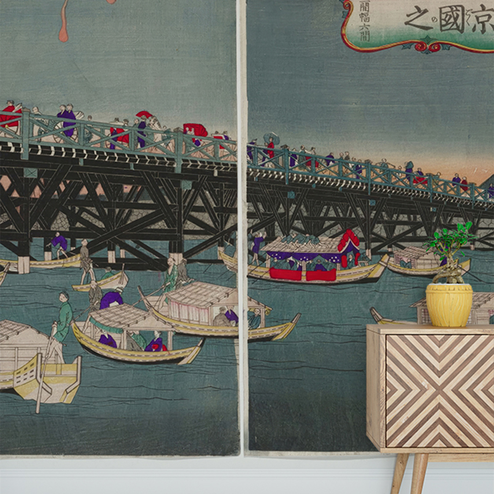 Japanese bridge scene with blue wallpaper behind a wooden cabinet and potted plant 